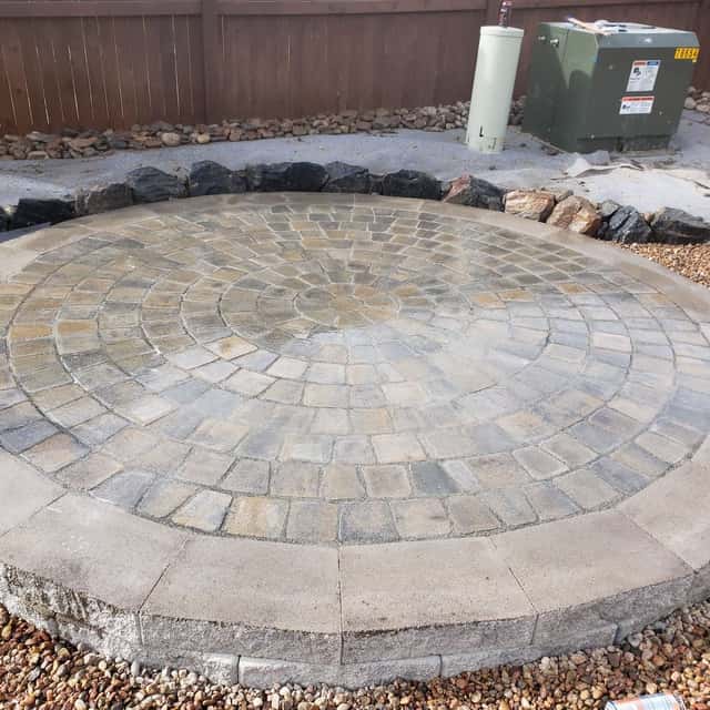 Circular paver patio set in river rock with boulder edging — Angel's Landscaping LLC, Castle Rock, CO