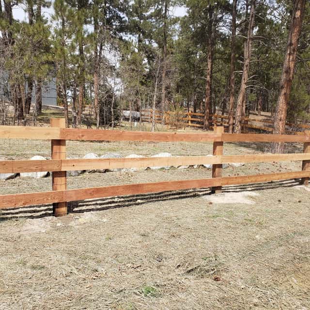 Split-rail fence running along a wooded property line — Angel's Landscaping LLC, Castle Rock, CO