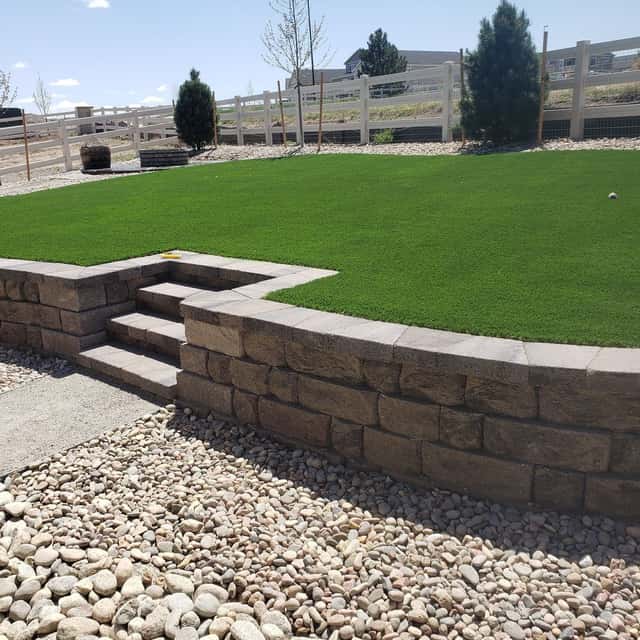 Block retaining wall with integrated steps and synthetic turf above — Angel's Landscaping LLC, Castle Rock, CO