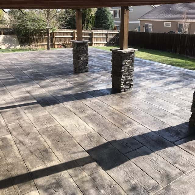 Stamped concrete patio with stone-veneer pergola columns — Angel's Landscaping LLC, Castle Rock, CO