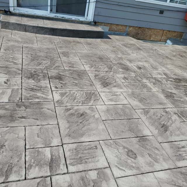 Ashlar-slate stamped concrete patio beside a house — Angel's Landscaping LLC, Castle Rock, CO